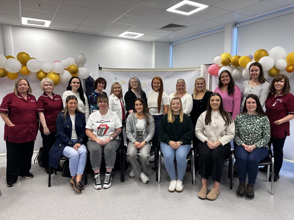 A group of newly qualified midwives pictured with midwives in uniform