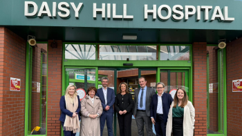 Northern Ireland Health Committee members alongside Trust leadership at the entrance to Daisy Hill Hospital