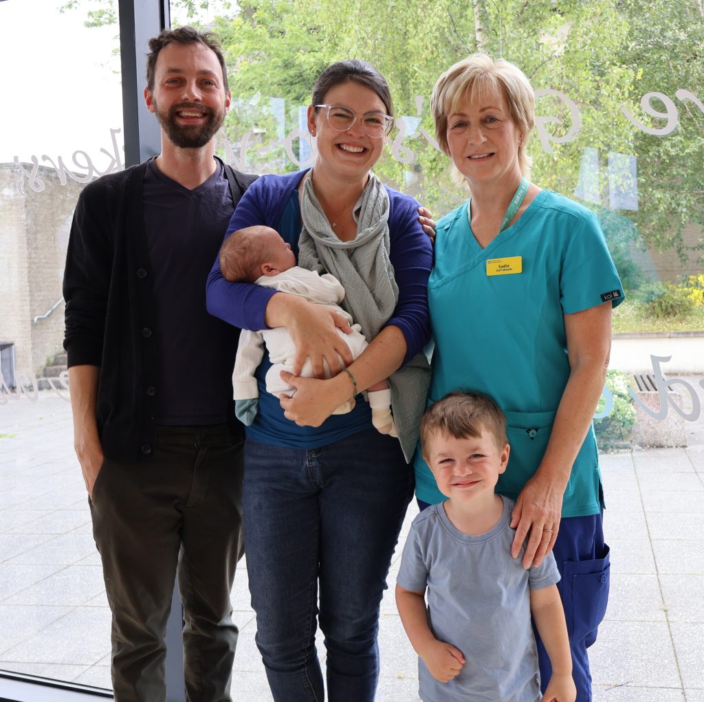Ruby & Nick with their family and Midwife Sadie